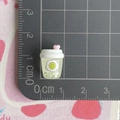 Gedetailleerd macro-zicht van een 1,5 cm mini hars kiwi drinkflesje bedeltje voor DIY crafts - Transparante groene kiwisapfles