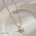Collier en acier titane doré avec pendentif tournesol en turquoise sur une assiette - Tournesol