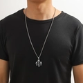 Vue détaillée du pendentif crâne sur une chaîne en acier inoxydable porté par un modèle - Crânes Multiples