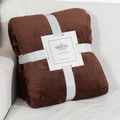 Deep brown waffle weave flannel blanket with gift ribbon and tag on cozy sofa - Brown