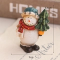 Resin snowman figurine wearing a blue hat and red scarf holding a tree, 6.5cm height - Snowman with Tree