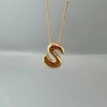 Macro detail of a 3D letter S pendant with golden finish on a fine O-link chain - Letter S Single Pendant