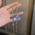 Macro view of long tassel earrings with blue butterfly charms and elegant white pearls - Blue Phantom Butterfly Pearl Tassel Style with 925 Sterling Silver Earring Post (13#)