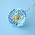 Macro detail of a hand-knitted blue corn poppy flower with a green stem and soft lighting - Blue