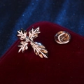 Classic golden cross lapel pin with leaf texture and crystal on red velvet background - Gold Decorative Cross