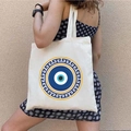White canvas tote bag featuring a blue Evil Eye print and golden Greek Meander pattern - STD1804-F Greek Meander Eye