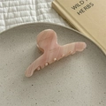 Dettaglio di un fermaglio per capelli in acetato rosa marmorizzato su piatto in ceramica - Rosa