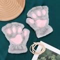 Detail view of plush cat paw fingerless gloves in grey on a rustic wooden tray - One Size / Gray