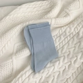 Mid-calf cotton socks in light blue color with ribbed cuffs on a white knit background - Blue