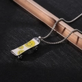 Macro shot of a silver skateboard pendant with yellow smiley faces and rotating wheels - XL19 / Skateboard Smiley / Silver Yellow