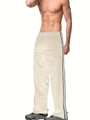 Detail view of cream white joggers with double black side stripes on model - Khaki