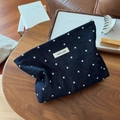 Close-up of blue polka dot denim cosmetic bag on a wooden table with home decor items - Polka Dot