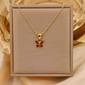 Macro shot of 18K gold butterfly necklace featuring four sparkling red zircon gemstones - Red N-133