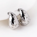 Macro detail of silver teardrop earrings with pavé cubic zirconia inlay on white porcelain - White Gold With White Zirconia