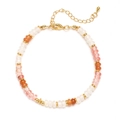 Nahaufnahme von buntem Naturstein-Armband mit goldenem Karabinerverschluss und Perlen - Rosa