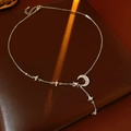 Detailopname van de zilveren ster-en-maan-ketting met zirkoon op bruin leer - Zilver