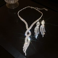 Sparkling silver fringe necklace and earring set with crystals on a black reflective background - Tassel Twist Starry Luxury / Silver