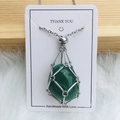 Collier cage en métal argenté avec pierre précieuse verte ovale sur carte décorative - Argent Aventurine Verte