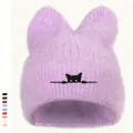 Detail der hellvioletten Plüsch-Strickmütze mit Katzenohren und Stickerei der Augen - Hellviolett
