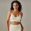 Detailopname van de naadloze geribbelde textuur en U-hals bandjes van de beige yogabh - S / crème