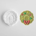 Christmas wreath cookie mold with candle patterns and finished frosted cookie - Christmas