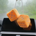 Detail of plush orange car dice hanging with purple heart patterns and white string - Orange with Purple Heart