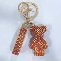 Detail of orange rhinestone bear keychain with glittering strap and gold metal hardware - Orange Yellow AB