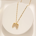 Collana con fiocco dorato e cristalli scintillanti su un piedistallo bianco - Oro