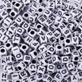 Close-up of white acrylic cube letter beads with black printed capital letters for DIY crafts - 6x6mm White With Black Letters (100pcs)
