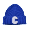 Macro detail of the white C letter patch on the navy blue ribbed knit beanie hat - Blue & White