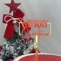 Close-up of red acrylic Merry Christmas cake topper with gold foil lettering on cake - Rectangle Merry Christmas