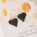 Close-up of black asymmetric heart earrings with gold flower zircon inlay and hooks - Black