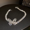 Macro shot of silver butterfly necklace with sparkling crystals on dark jewelry tray - Silver