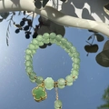 Exquisite green beaded bracelet with a gold clover charm on a reflective mirror background - S048-green Four-leaf Clover Jade Beaded Bracelet #sz356