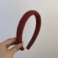 Close-up of a reddish-brown tweed padded headband with handmade label detailing - Woolen Headband / Burgundy