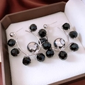 Detail view of C-shaped earrings with black faceted beads and silver metal accents - Silver Pin - Silver & Black
