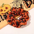 Close-up of Halloween scrunchie with pumpkin and skull patterns on glossy satin fabric - No. 6 Large Scrunchie / Large Size