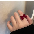 Gros plan d'une bague nœud en velours rouge montrant des détails vintage élégants - Rouge