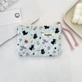 Close-up of light blue quilted makeup bag featuring cute cat patterns and purple rope zipper pull - Black Cat Dots