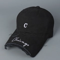 Détail d'une casquette noire avec broderie C blanche et bord de visière usé - Noir