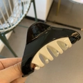 Detail of minimalist black and white two-tone triangle hair claw clip in hand - Black and White Patchwork