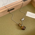 Detailed shot of retro tiger eye stone necklace with silver horse pendant on green fabric - Silver Pony Tiger Eye Retro (40#)