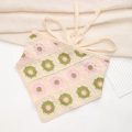 Dettaglio di una bandana all'uncinetto fatta a mano con fiori rosa e foglie verdi - Bandana Unità Floreale Bianco Crema