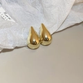 Detailed view of polished gold teardrop earrings with a reflective metallic finish - Gold