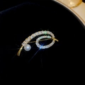 Elegante spilla placcata oro con zirconi e perla, caratterizzata da linee fluide - Oro