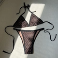 Set bikini in pizzo nero con fodera beige steso su un tappetino intrecciato con ombre - S / Nero