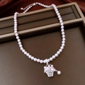 Dettaglio della collana di perle con ciondolo vintage a cesto di fiori sul vassoio - Collana - Argento - Rosa