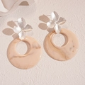 Detailed shot of resin hollow flower earrings with silver studs and marble texture - White