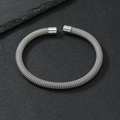 Detalle de brazalete de malla de acero inoxidable plateado sobre un fondo oscuro - 6mm / Color Acero