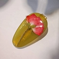 Pasador de gota en resina hecho a mano con rosa roja preservada sobre fondo blanco - Verde